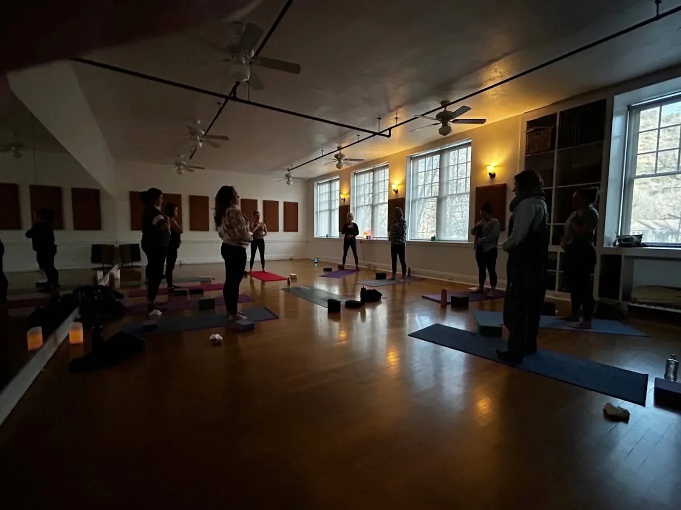 An evening movement class in session in the candlelit studio at Live Well Durango.