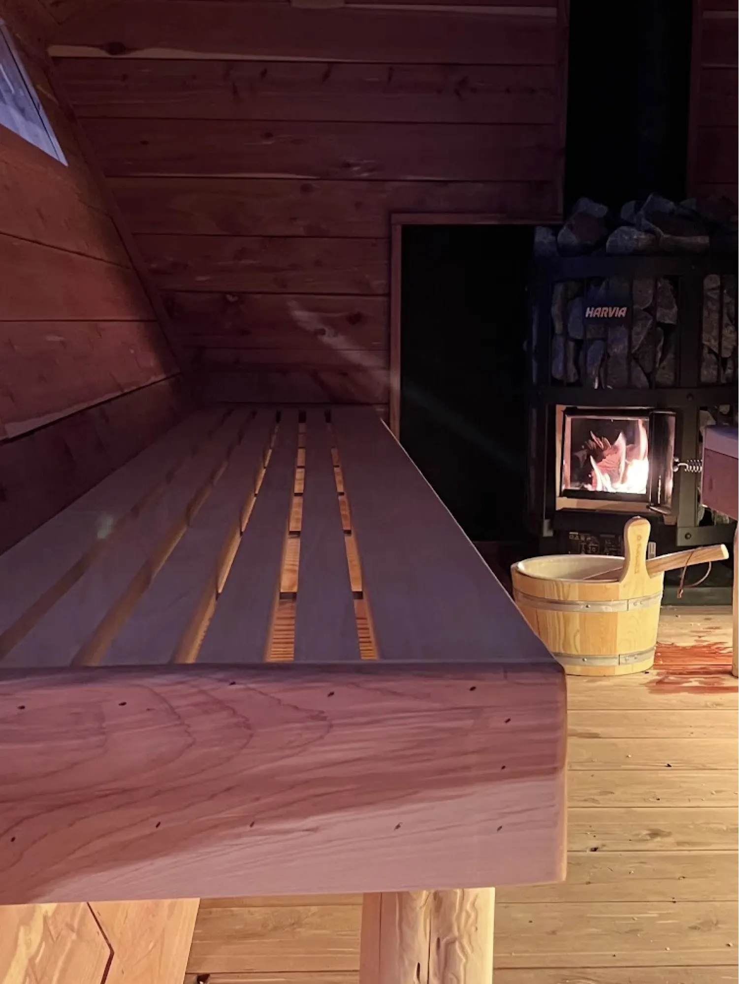 Cedar benches and a wood-fired Harvia stove inside a sauna at Third Space & Co.