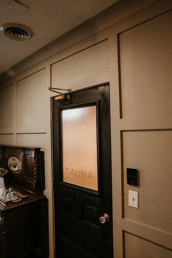 The frosted-glass sauna door in a quiet, panelled hallway at William Henry the Spa.